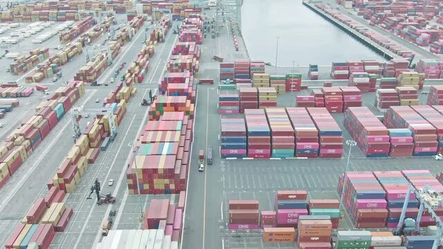 Aerial view of container ship in sea port. Global shipping industry. container cargo vessel freight. Semi trucks loading cargo containers. Shipment from China. Drone shot 4k. Global import export 