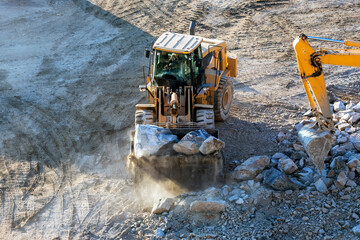 Bulldozer is working in site. A bulldozer or dozer is a large, motorized machine that travels on continuous tracks or large tires and is equipped with a metal blade to the front for pushing material. © Funtay