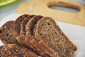 Sliced rye bread with sunflower and poppy seeds on rustic wooden background. Healthy food still life