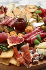 Different tasty appetizers on wooden board, closeup