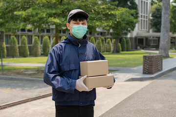 Parcel delivery concept the young sender lifting two boxes of parcels and standing in middle of...