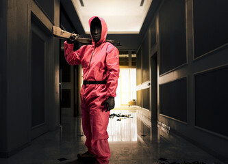 Criminal man in pink guard uniform holding the shotgun while robbery the house