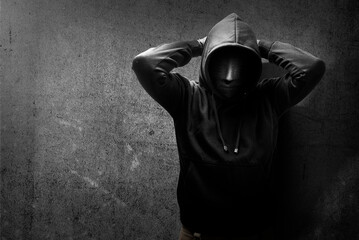 A criminal man in a hidden mask raised a hand behind the head for arrested