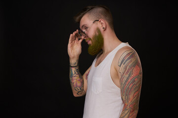 bearded man in white t-shirt with tattoos on his arms posing bully