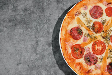 Delicious pepperoni pizza on a gray concrete background. Top view of hot freshly made pepperoni pizza. Layout with space for copying text. Banner idea