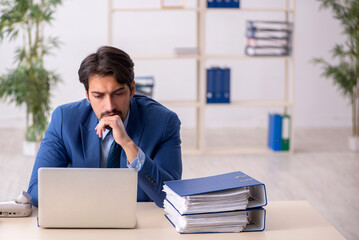 Young male employee and too much work in the office