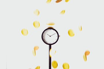 Gold coins fall on the black clock. The concept of time is money