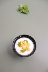 Boondi Raita or Dahi Bundi rayta is a Popular condiment from Rajasthan, India. Served with coriander toppings in a bowl over the flat background. copy space. Yogurt dip. 