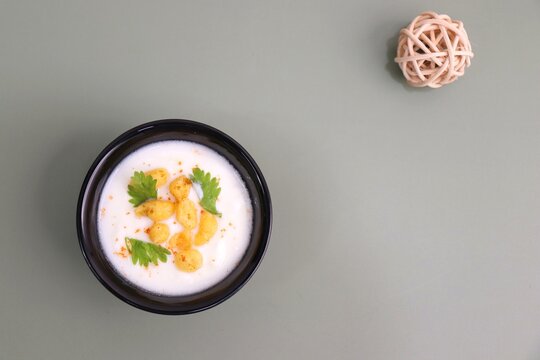 Boondi Raita or Dahi Bundi rayta is a Popular condiment from Rajasthan, India. Served with coriander toppings in a bowl over the flat background. copy space. Yogurt dip. 