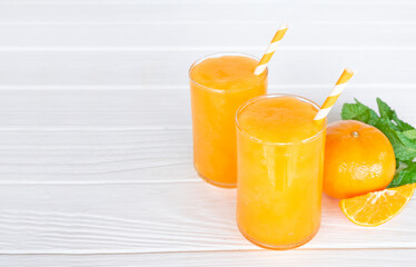 Orange smoothies yellow colorful fruit juice milkshake blend beverage healthy high protein the taste yummy In glass,drink to lose weight drink episode morning on white gray background.