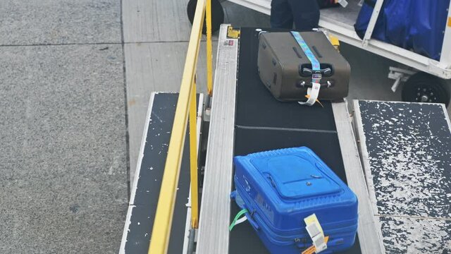 Luggage sliding on automatic conveyor into the plane