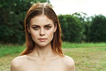 pretty woman in a field outdoors bare shoulders clear skin cropped view