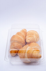 Croissant in a plastic box.Bread in white background.French traditional bread.