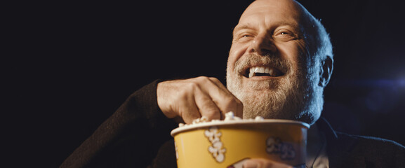 Senior man watching a comedy movie at the cinema