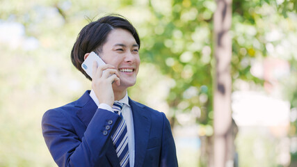 スマホで話す若い男性ビジネスマン