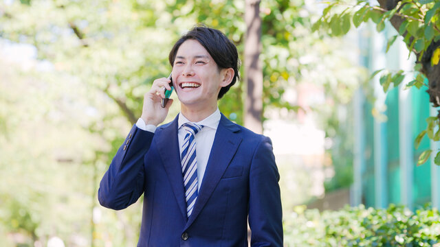 スマホで話す若い男性ビジネスマン