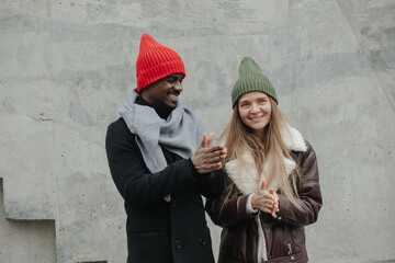 Good opposite sex friends hanging out on the street, rubbing hands for warmth