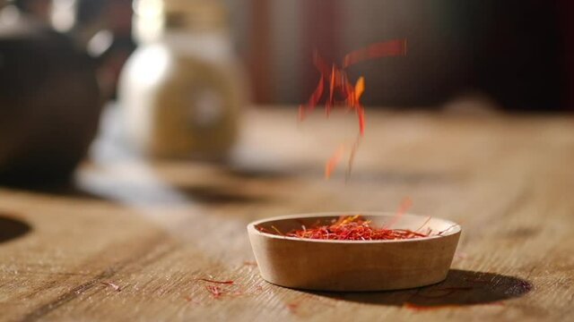 A motion of dropping down of herb and species into a wooden dish for chinese traditional medicine , healthcare content , closeup view