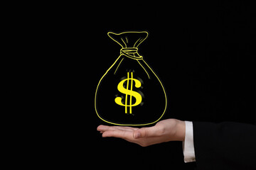a bag of money in his hand on a black background, a business man holds a wallet with a dollar...