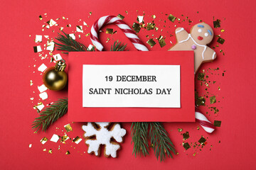 Card with text 19 December Saint Nicholas Day and festive decor on red background, flat lay - Powered by Adobe