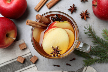 Aromatic hot mulled cider on grey table, flat lay