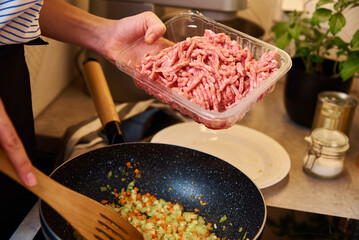 Woman cooking sauce bolognese in kitchen