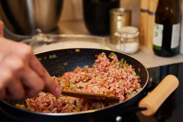 Woman cooking sauce bolognese in kitchen