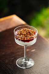 Granola berry trifle dessert in a fancy glass on the table