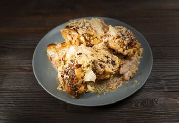 Chicken thighs with sweet paprika in sour cream on a brown wooden table.