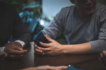 Obraz premium professional business person holding smartphone and using to work with communication technology, smart mobile phone, people smiling and happy at modern office