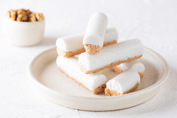 Raw carrot sticks with coconut cream on a light plate. Sugar, gluten and lactose free and vegan.