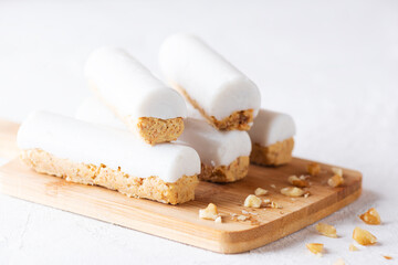 Carrot sticks with coconut cream and walnuts on a wooden board. Sugar, gluten and lactose free and vegan.