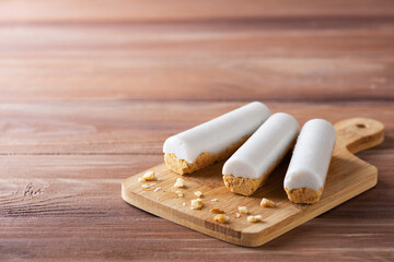 Carrot sticks with coconut cream on a wooden board. Sugar, gluten and lactose free and vegan. Horizontal orientation, copy space.