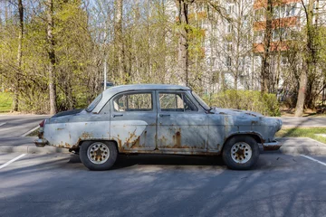 Deurstickers A car in patina on a city street. © Андрей Козичев