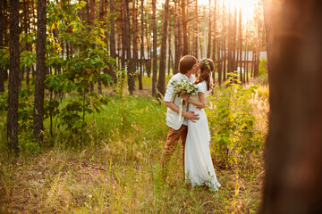 a man and a woman in white outfits and with flowers are walking in the park