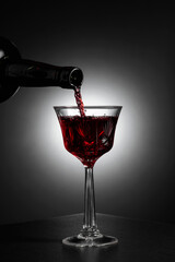 Dessert wine or liqueur is poured into a glass from an ancient bottle.