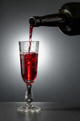 Dessert wine or liqueur is poured into a glass from an ancient bottle.