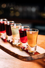 Various assorted alcohol shot drinks on the wooden bar desk