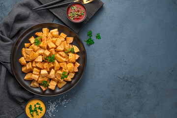 Patatas bravas with sauce on a graphite background with space to copy.