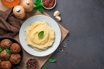 Dinner with mashed potatoes and meatballs on a dark background.