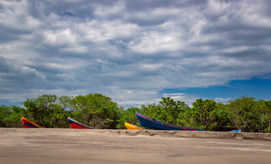 four boats parked on the sand, fishing boats parked near the ocean, boats stranded on the ocean shore with blue sky