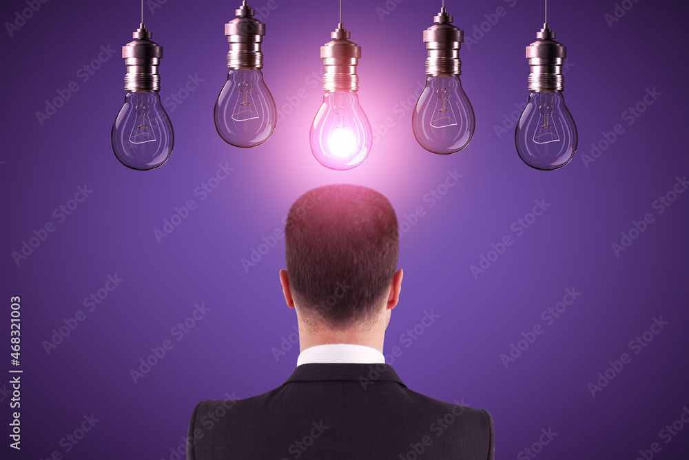 Poster back view of young european businessman looking at abstract glowing row of light bulbs on purple bac