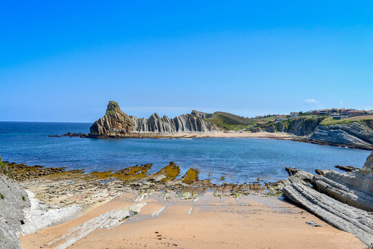 View of Portio beach in Liencres, with its colored sand and rocks.