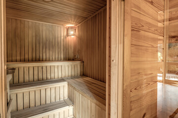 Fototapeta na wymiar Large standard design classic wooden russian bath sauna interior with hot stones