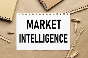 MARKET INTELLIGENCE. text on white sheet of paper on torn paper background