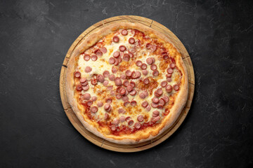 delicious pizza with cheese and sausages, Pepperoni , sausages, on a black background top view