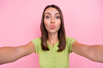 Fototapeta premium Photo of flirty brunette young lady do selfie blow kiss wear green top isolated on pink color background