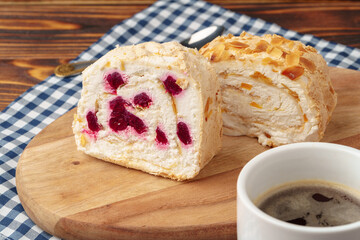 Biscuit roulade with cherry on wooden board