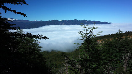 Obraz na płótnie Canvas Mountains above clouds, View from mountainside to valley filled with clouds, Puyehue National Park, Los Lagos Region, Chile