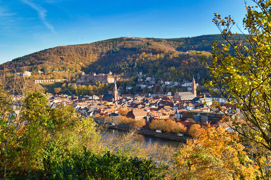 View from path called 'Philosophenweg' over old historic Heidelberg city with Odenwald forest and castle on beautiful autumn day in Germany